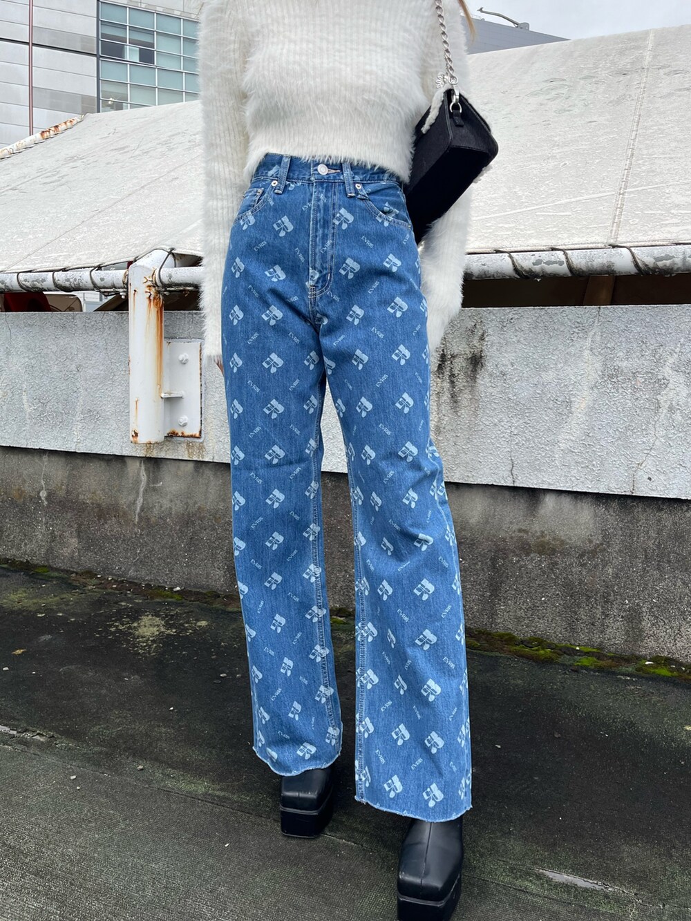 ホワイト系のニット/セーター、ブルー系のデニムパンツ、ブラック系のブーツを着用したレディースの秋コーディネートの5枚目の写真