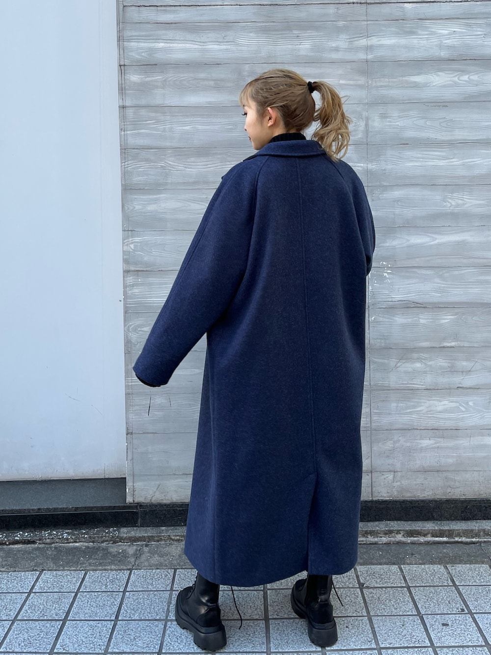 ブラック系のその他アウター、グレー系のニット/セーター、ブラック系のブーツを着用したレディースの冬コーディネートの2枚目の写真