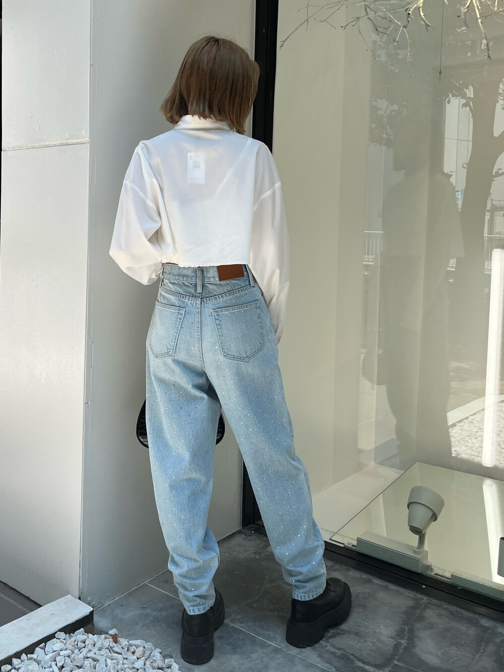 ホワイト系のシャツ/ブラウス、ブルー系のデニムパンツ、ブラック系のショルダーバッグを着用したレディースの秋コーディネートの5枚目の写真