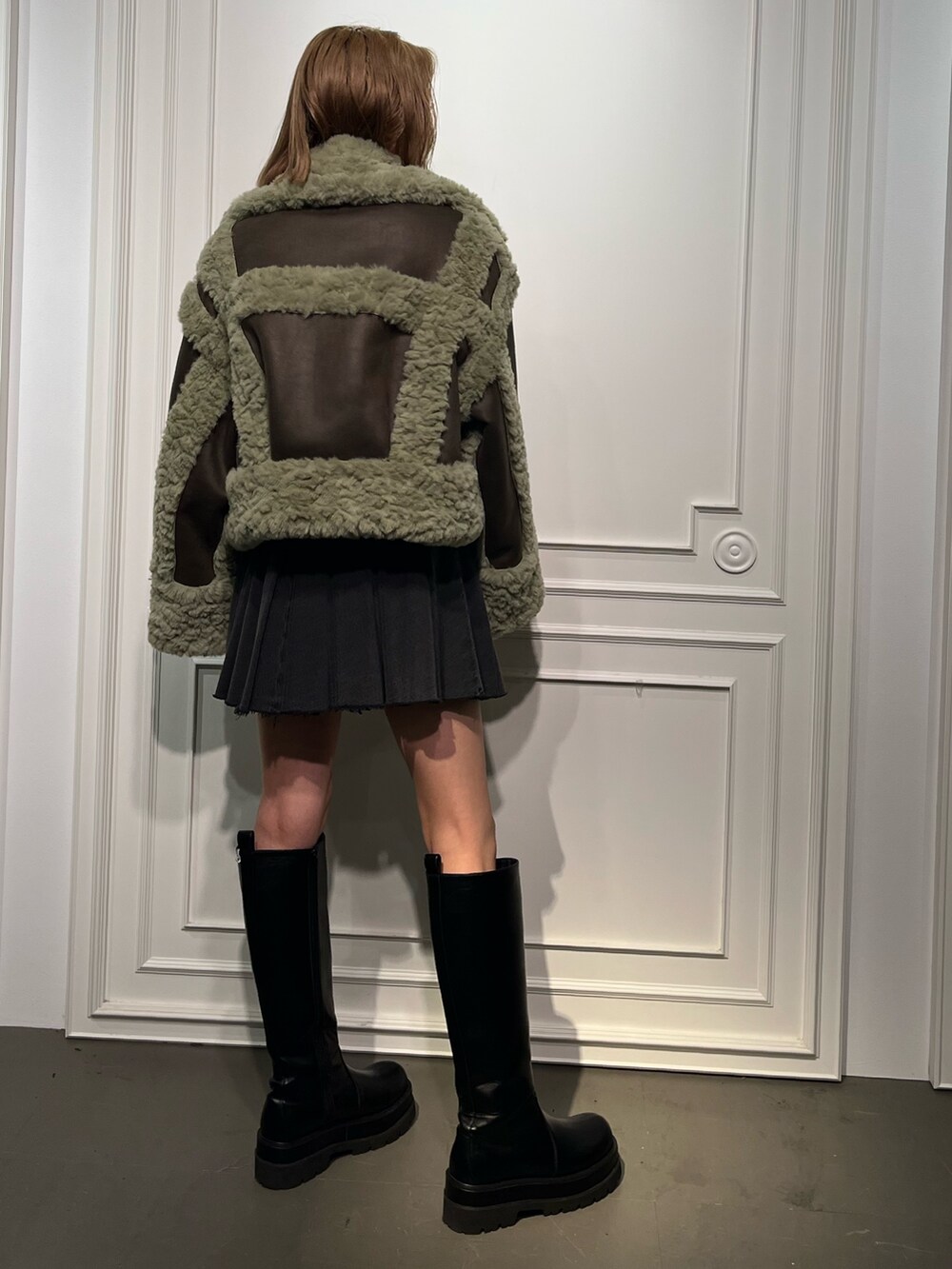 ブラック系のブーツ、ブラック系のデニムスカート、ホワイト系のTシャツ/カットソーを着用したレディースの夏コーディネートの2枚目の写真