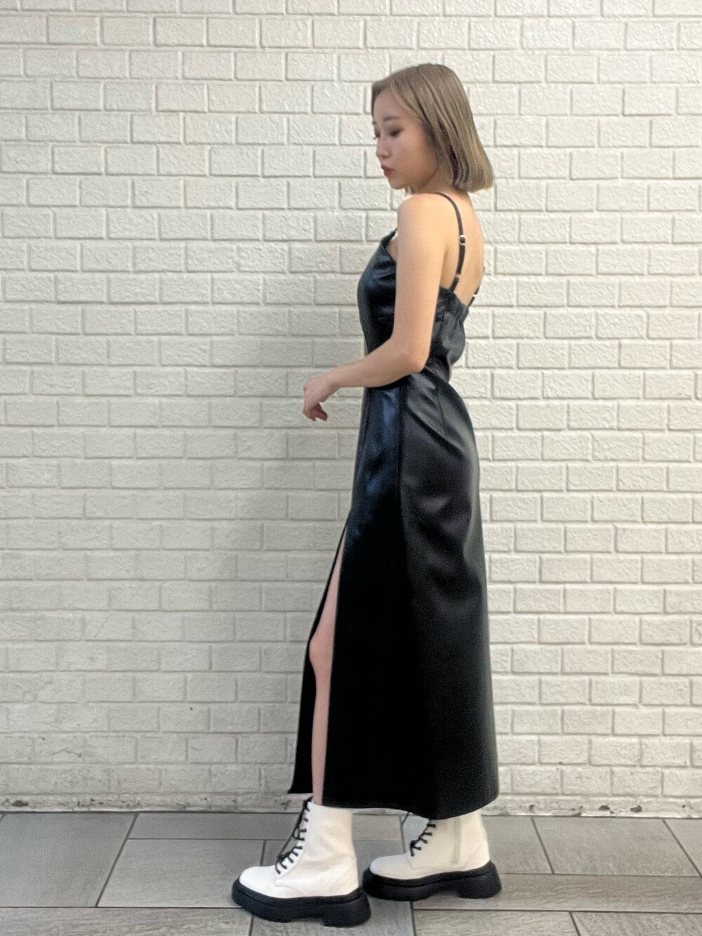 ブラック系のワンピース、ブルー系のデニムジャケット、ホワイト系のブーツを着用したレディースの冬コーディネートの3枚目の写真