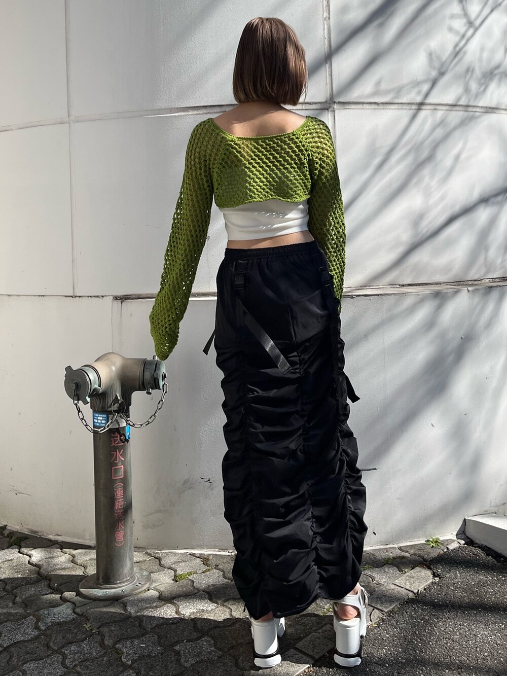 ブラック系のスカート、ブラック系のニット/セーターを着用したレディースの春コーディネートの3枚目の写真