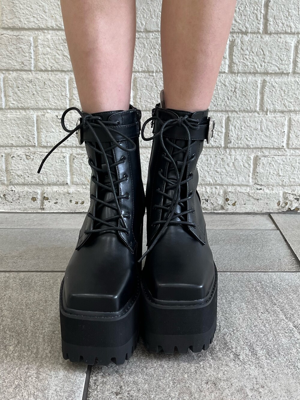 オレンジ系のテーラードジャケット、オレンジ系のキャミソール、ブラック系のブーツを着用したレディースの冬コーディネートの8枚目の写真