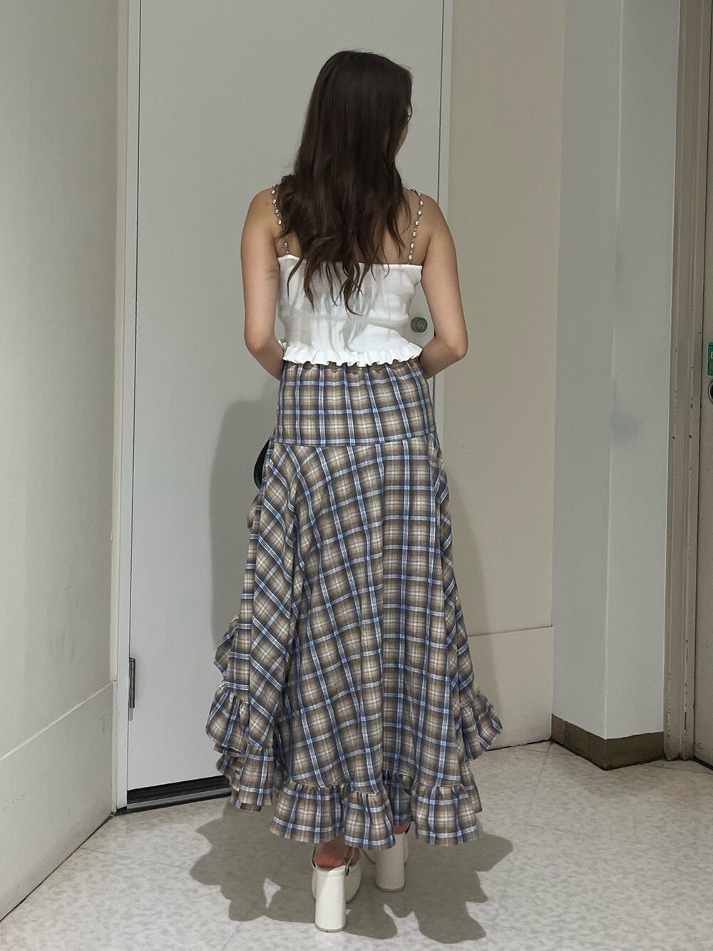 グレー系のスカート、レッド系のキャミソール、ブラック系のハンドバッグを着用したレディースの夏コーディネートの3枚目の写真