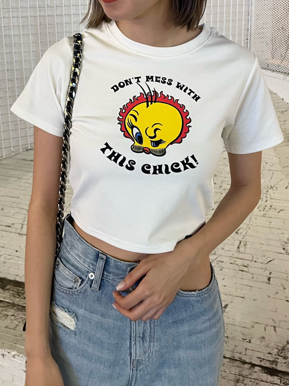 ブルー系のデニムパンツ、ホワイト系のTシャツ/カットソー、ブラック系のショルダーバッグを着用したレディースの夏コーディネートの4枚目の写真