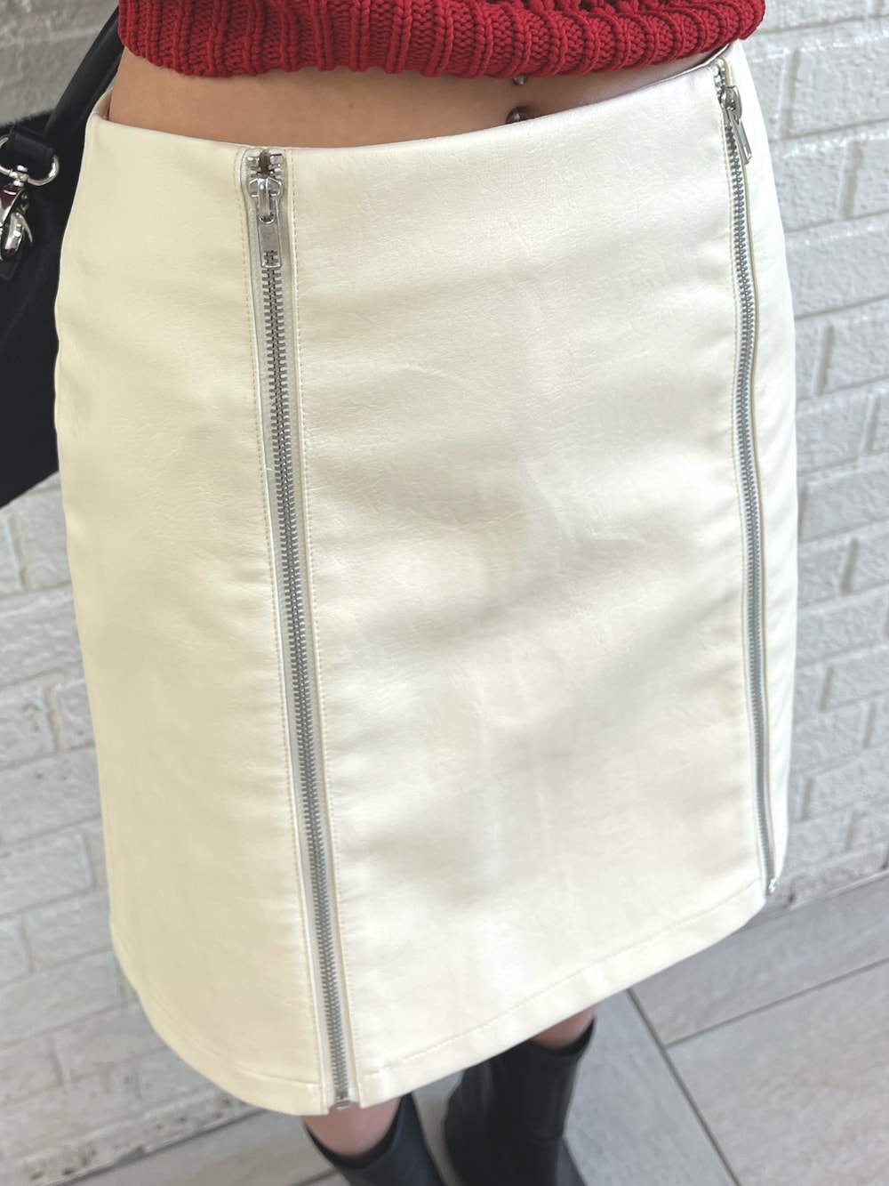 ブラック系のブーツ、ホワイト系のダウンジャケット/コート、ブラック系のショルダーバッグを着用したレディースの冬コーディネートの6枚目の写真