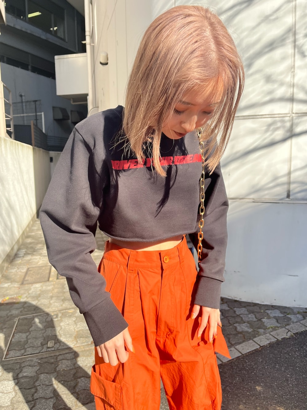 オレンジ系のカーゴパンツ、ホワイト系のブーツ、ブラック系のTシャツ/カットソーを着用したレディースの冬コーディネートの3枚目の写真
