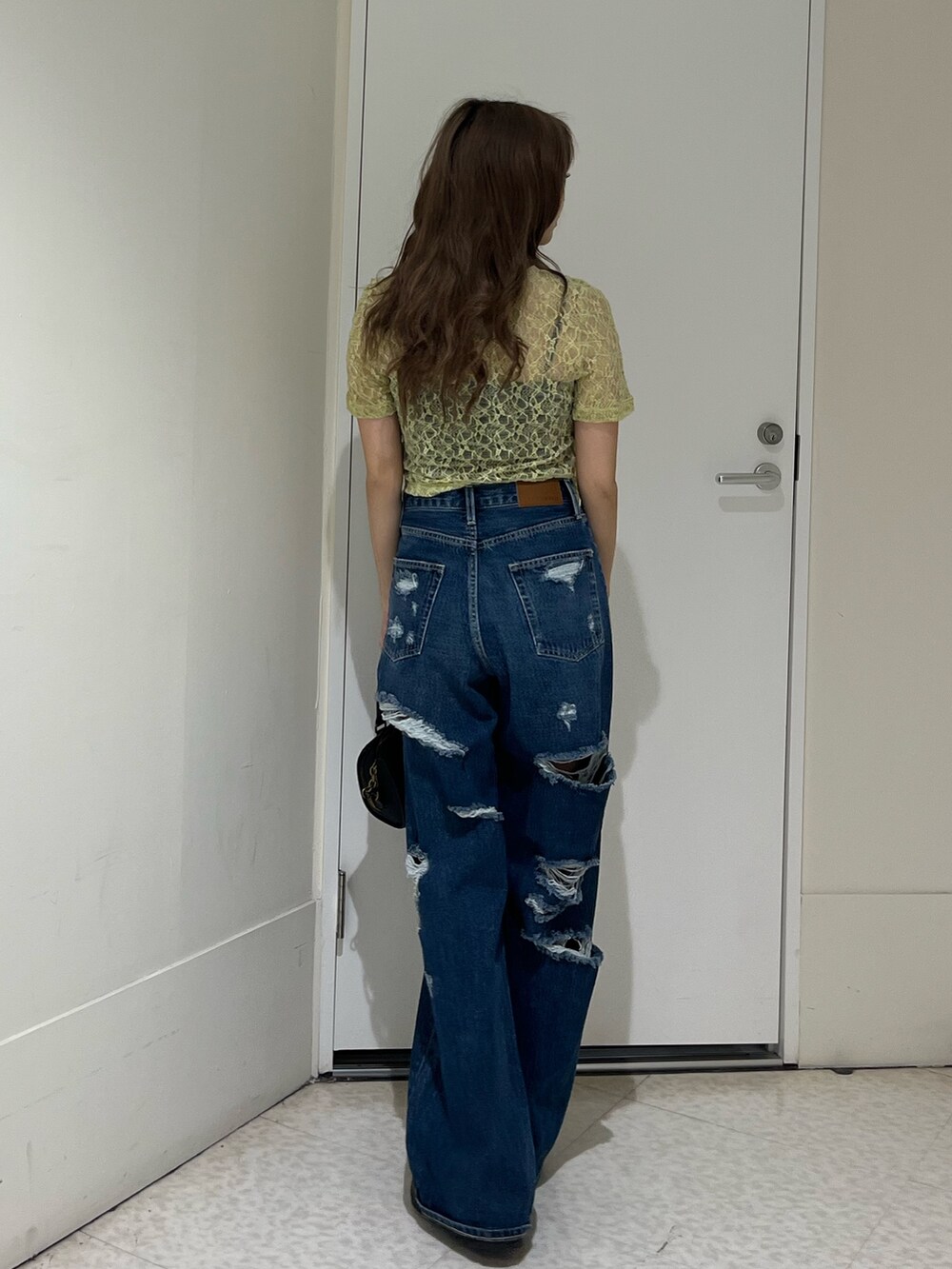 イエロー系のTシャツ/カットソー、ブルー系のデニムパンツ、その他のショルダーバッグを着用したレディースの春コーディネートの3枚目の写真