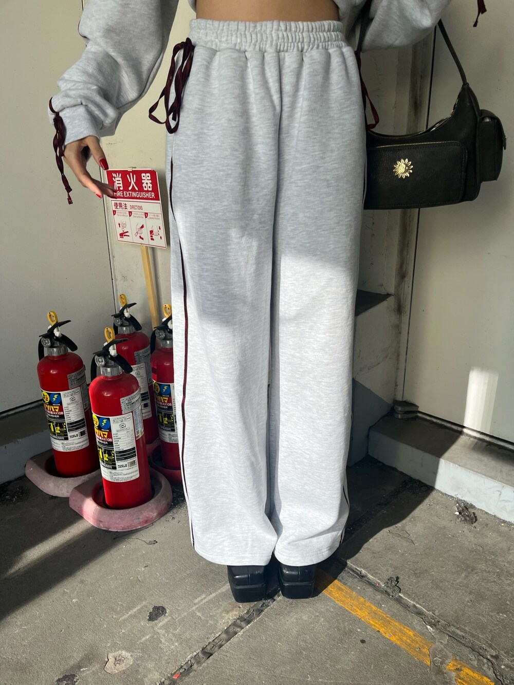 グレー系のスウェット、グレー系のスウェットパンツ、ブラック系のブーツを着用したレディースの冬コーディネートの5枚目の写真