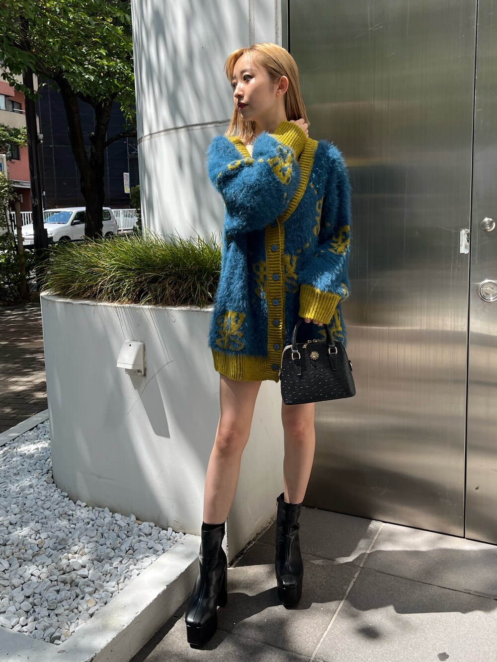 ブルー系のカーディガン/ボレロ、ブラック系のブーツ、ブラック系のショルダーバッグを着用したレディースの秋コーディネートの3枚目の写真