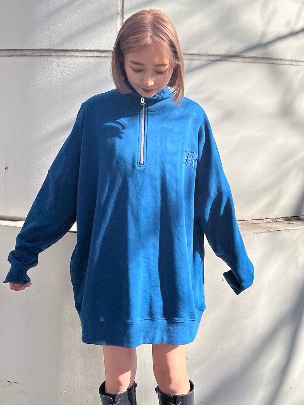 ブルー系のスウェット、ブラック系のブーツを着用したレディースの冬コーディネートの3枚目の写真