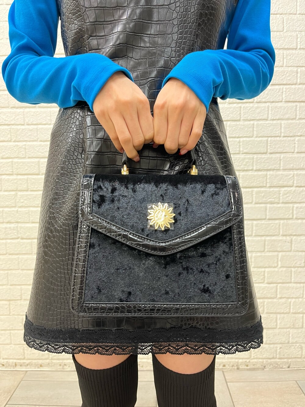 ブラック系のブーツ、ブラック系のワンピース、ブルー系のTシャツ/カットソーを着用したレディースの秋コーディネートの5枚目の写真