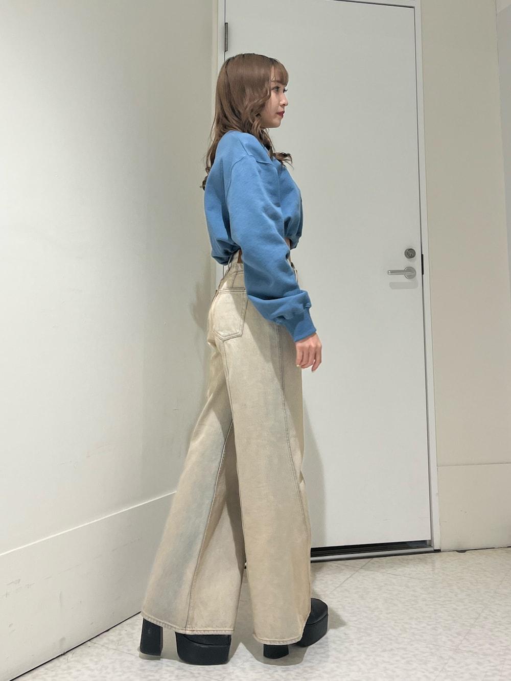 ブラック系のブーツ、ベージュ系のデニムパンツ、ブルー系のスウェットを着用したレディースの冬コーディネートの3枚目の写真