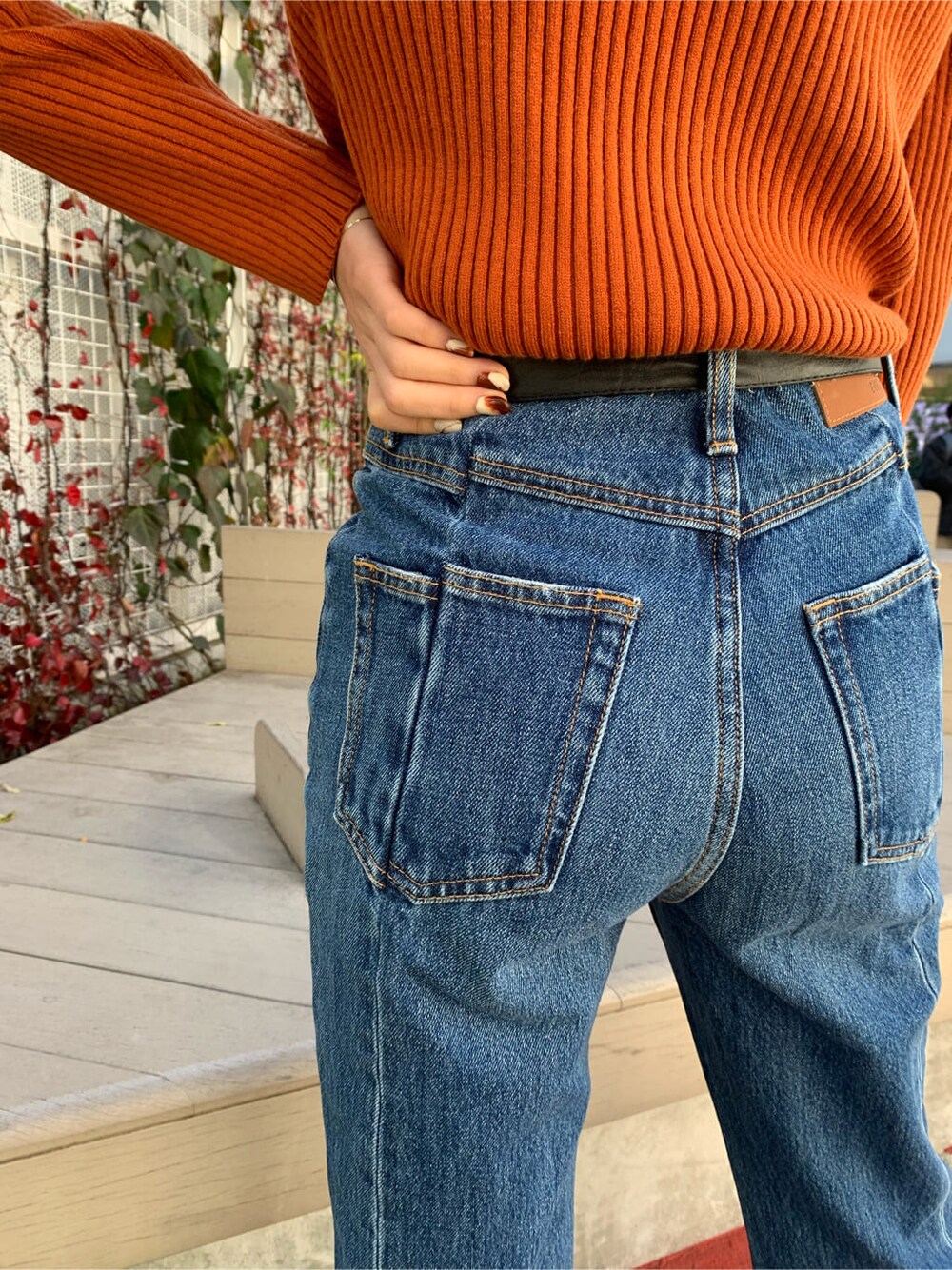 ブラック系のブーツ、ホワイト系のブルゾン、ブルー系のデニムパンツを着用したレディースの冬コーディネートの6枚目の写真