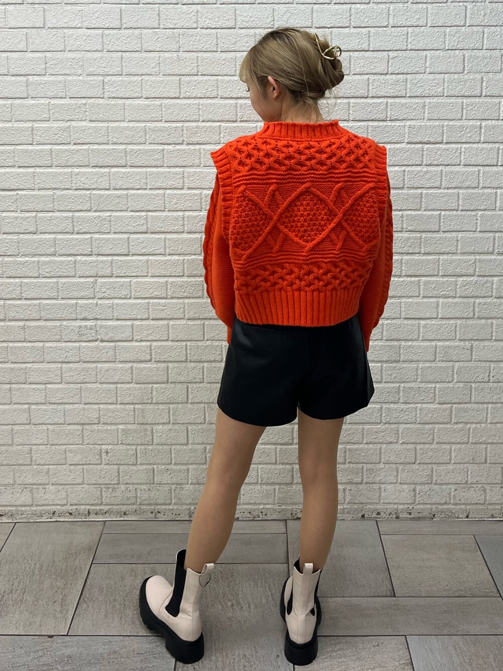 ホワイト系のブーツ、ブラック系のその他パンツ、ホワイト系のニット/セーターを着用したレディースの冬コーディネートの2枚目の写真