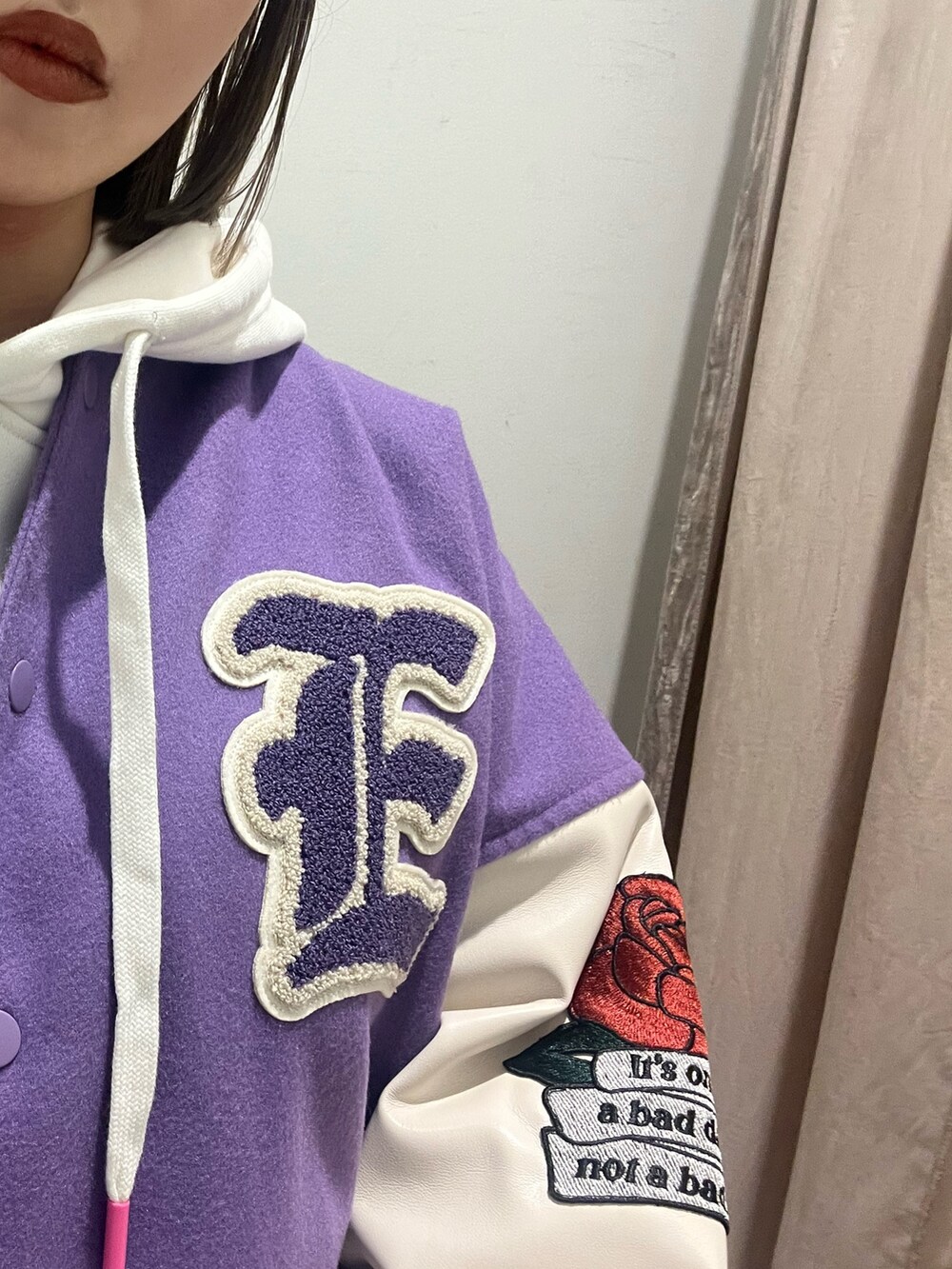 ホワイト系のパーカー、パープル系のスタジャン、ブラック系のブーツを着用したレディースの冬コーディネートの4枚目の写真