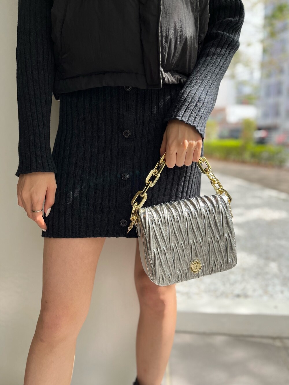 ホワイト系のブーツ、シルバー系のショルダーバッグ、ブラック系のワンピースを着用したレディースの秋コーディネートの6枚目の写真