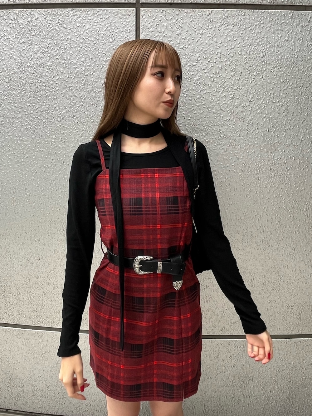 ブラック系のTシャツ/カットソー、レッド系のワンピース、ブラック系のブーツを着用したレディースの秋コーディネートの4枚目の写真