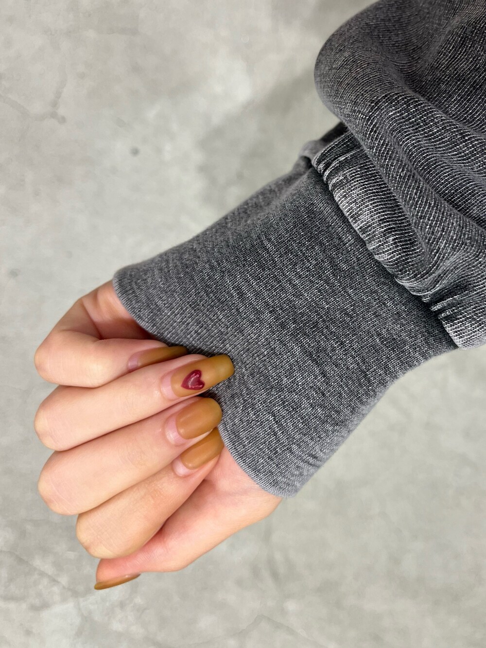 グレー系のTシャツ/カットソー、ブラック系のショルダーバッグ、ブラック系のブーツを着用したレディースの冬コーディネートの7枚目の写真