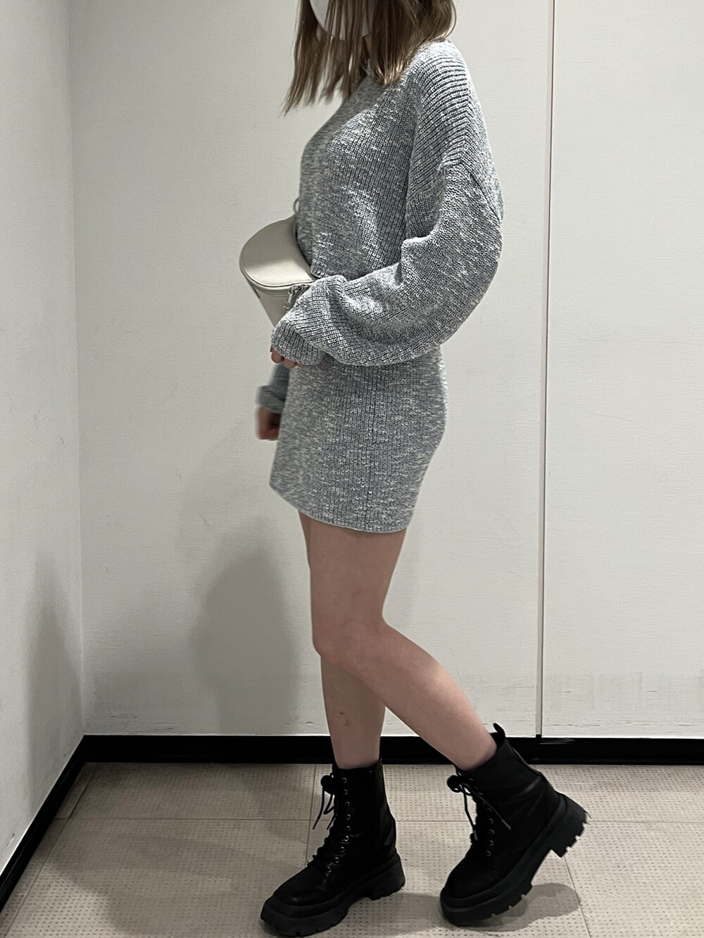 シルバー系のボディバッグ/ウエストポーチ、シルバー系のブーツ、ブルー系のワンピースを着用したレディースの春コーディネートの2枚目の写真