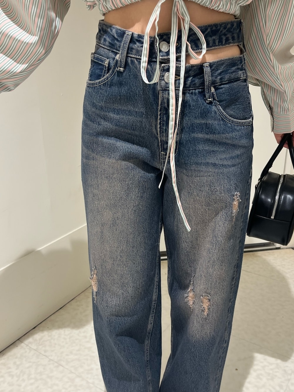 ブルー系のシャツ/ブラウス、ブルー系のデニムパンツ、ブラック系のブーツを着用したレディースの春コーディネートの6枚目の写真