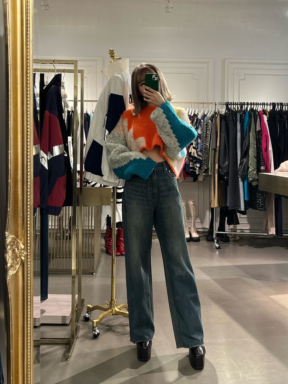 ブラック系のボストンバッグ、ブルー系のニット/セーター、ブルー系のデニムパンツを着用したレディースの冬コーディネートの8枚目の写真