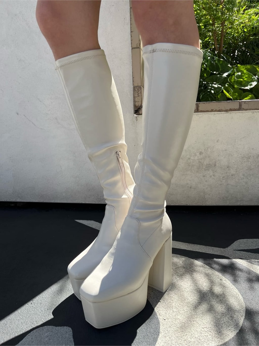 ブラウン系のスカート、ブラック系のニット/セーター、ブラック系のブーツを着用したレディースの秋コーディネートの4枚目の写真