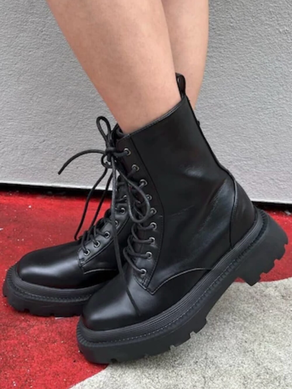 レッド系のニット/セーター、シルバー系のブーツ、ホワイト系のショルダーバッグを着用したレディースの夏コーディネートの7枚目の写真