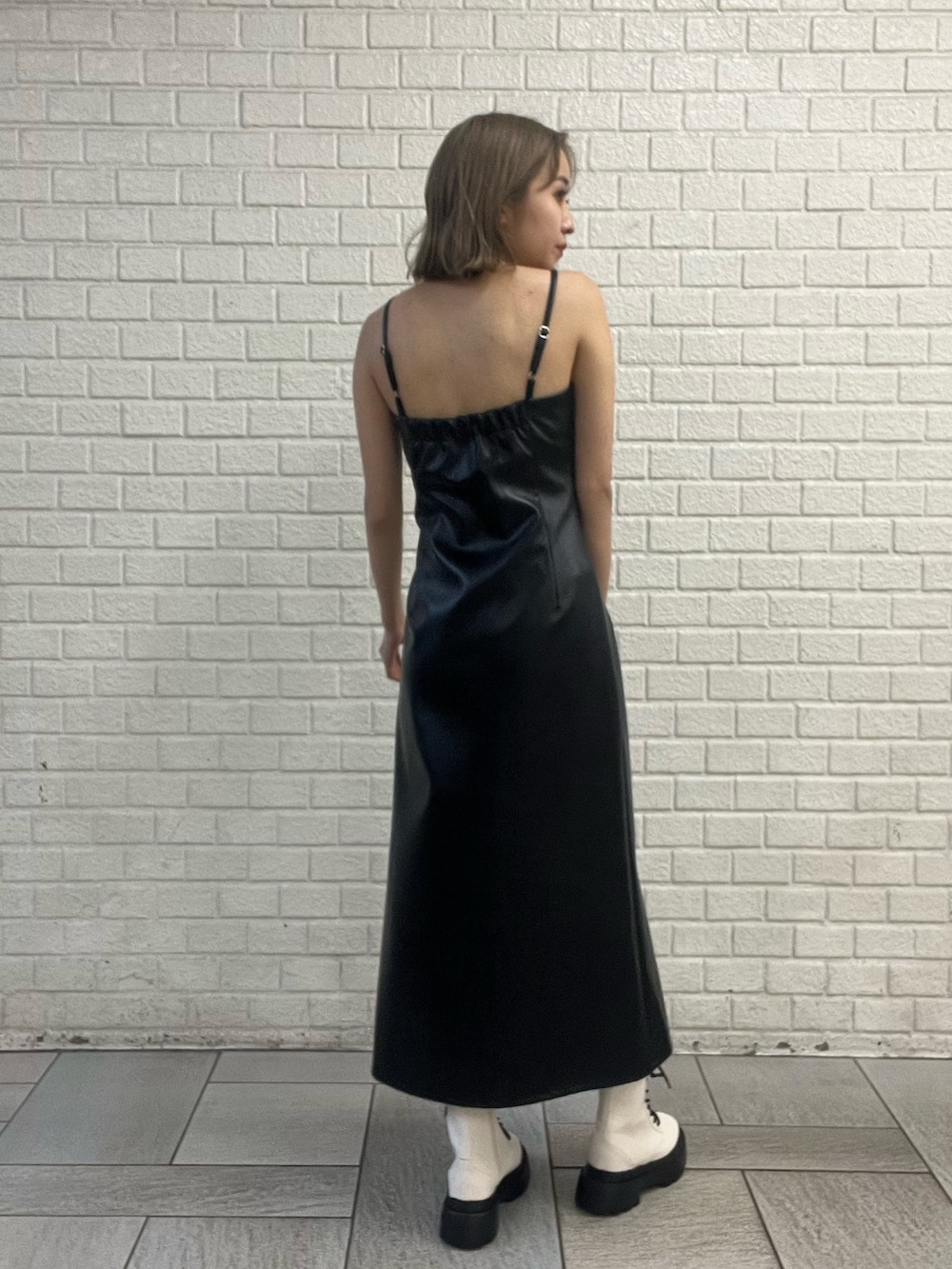 ブラック系のワンピース、ブルー系のデニムジャケット、ホワイト系のブーツを着用したレディースの冬コーディネートの4枚目の写真