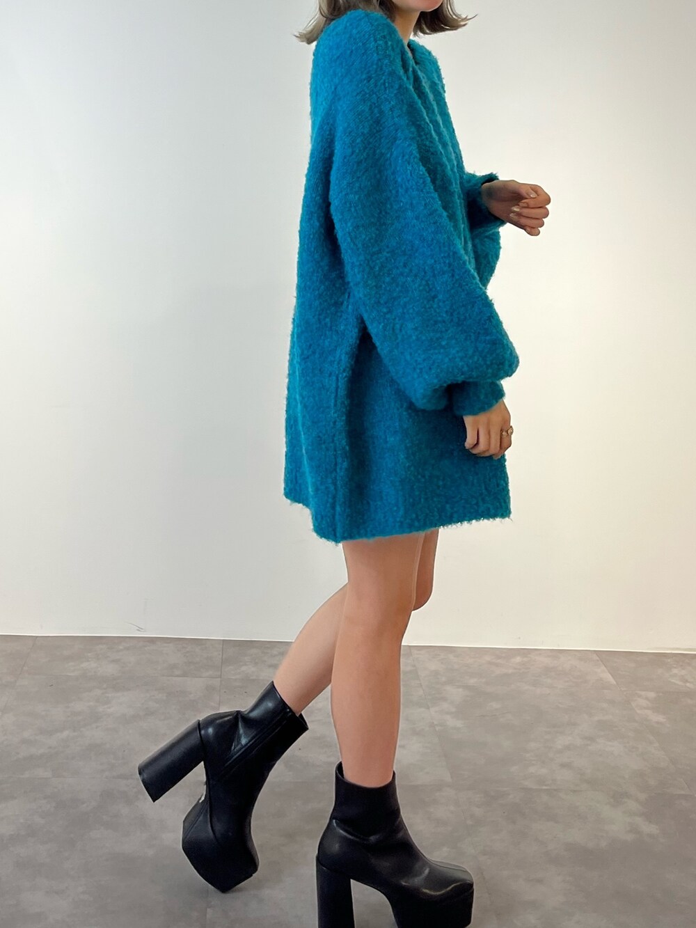 ブルー系のニット/セーター、ブラック系のブーツを着用したレディースの冬コーディネートの6枚目の写真