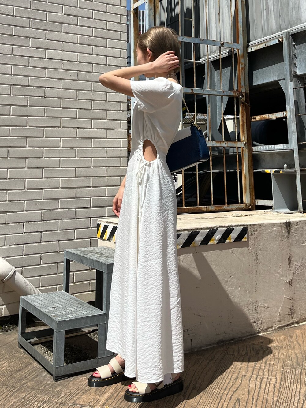 ホワイト系のワンピース、ベージュ系のサンダル、ブルー系のショルダーバッグを着用したレディースの春コーディネートの8枚目の写真