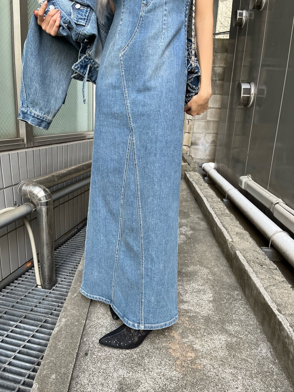 ブルー系のデニムジャケット、ブルー系のワンピース、ブルー系のショルダーバッグを着用したレディースの冬コーディネートの7枚目の写真