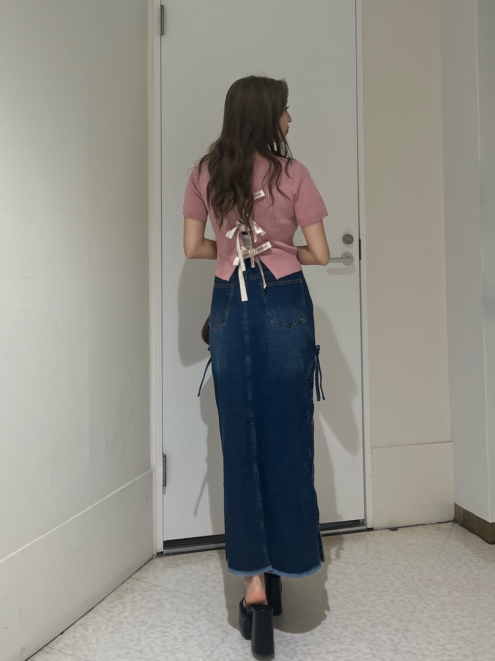 ブラウン系のハンドバッグ、ブラック系のサンダル、ブルー系のデニムスカートを着用したレディースの夏コーディネートの3枚目の写真