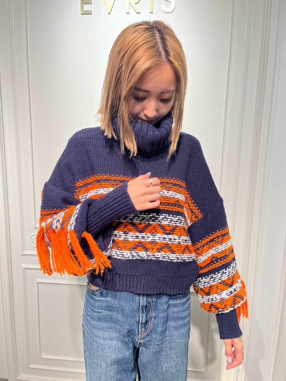 ブルー系のニット/セーター、ブラック系のブーツ、ブラック系のデニムパンツを着用したレディースの秋コーディネートの5枚目の写真