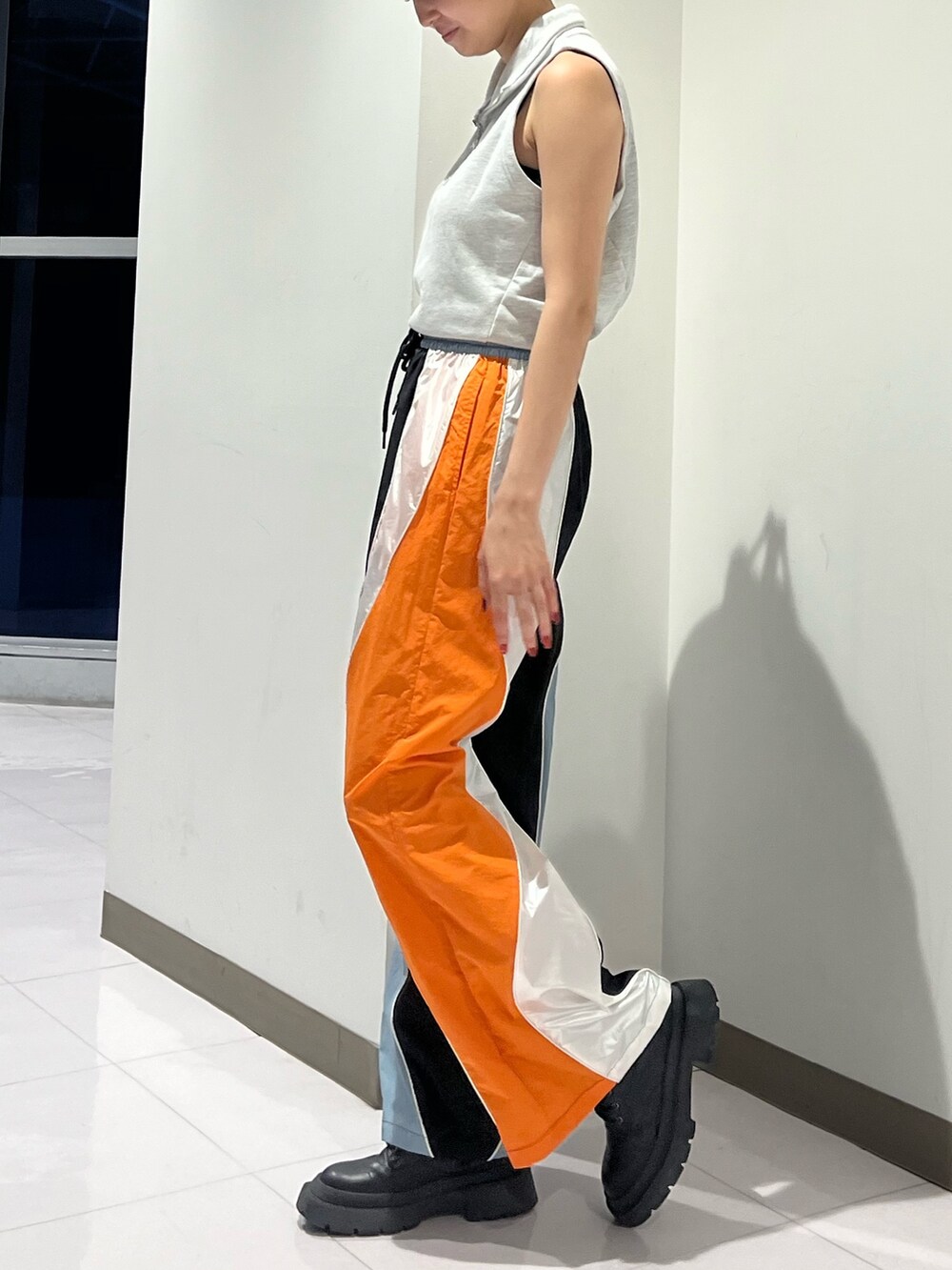 グレー系のTシャツ/カットソー、ブラック系のその他パンツ、シルバー系のブーツを着用したレディースの夏コーディネートの2枚目の写真