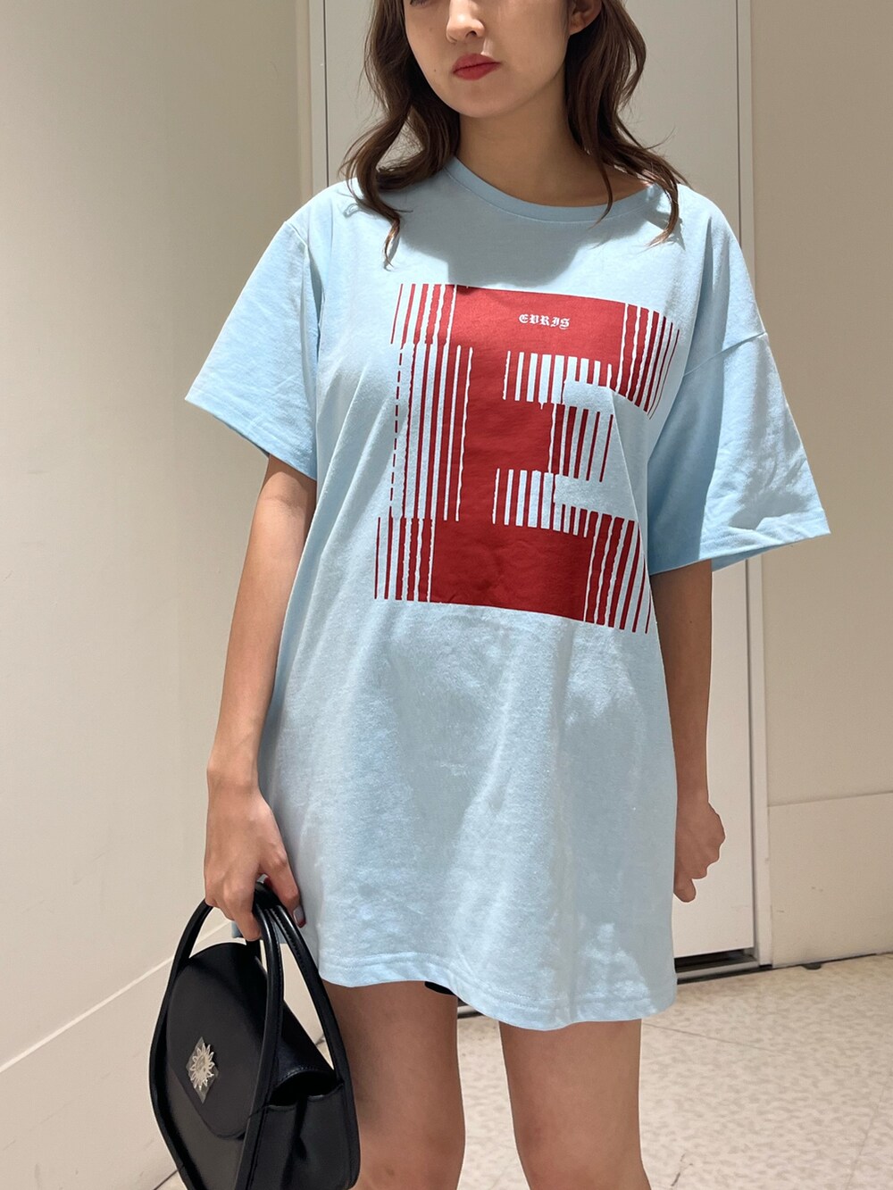 ブラック系のハンドバッグ、ブラック系のブーツ、ブルー系のTシャツ/カットソーを着用したレディースの春コーディネートの6枚目の写真
