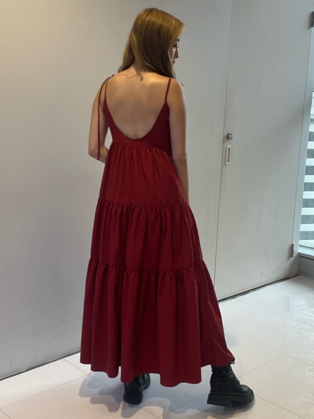 レッド系のワンピース、シルバー系のブーツを着用したレディースの夏コーディネートの3枚目の写真