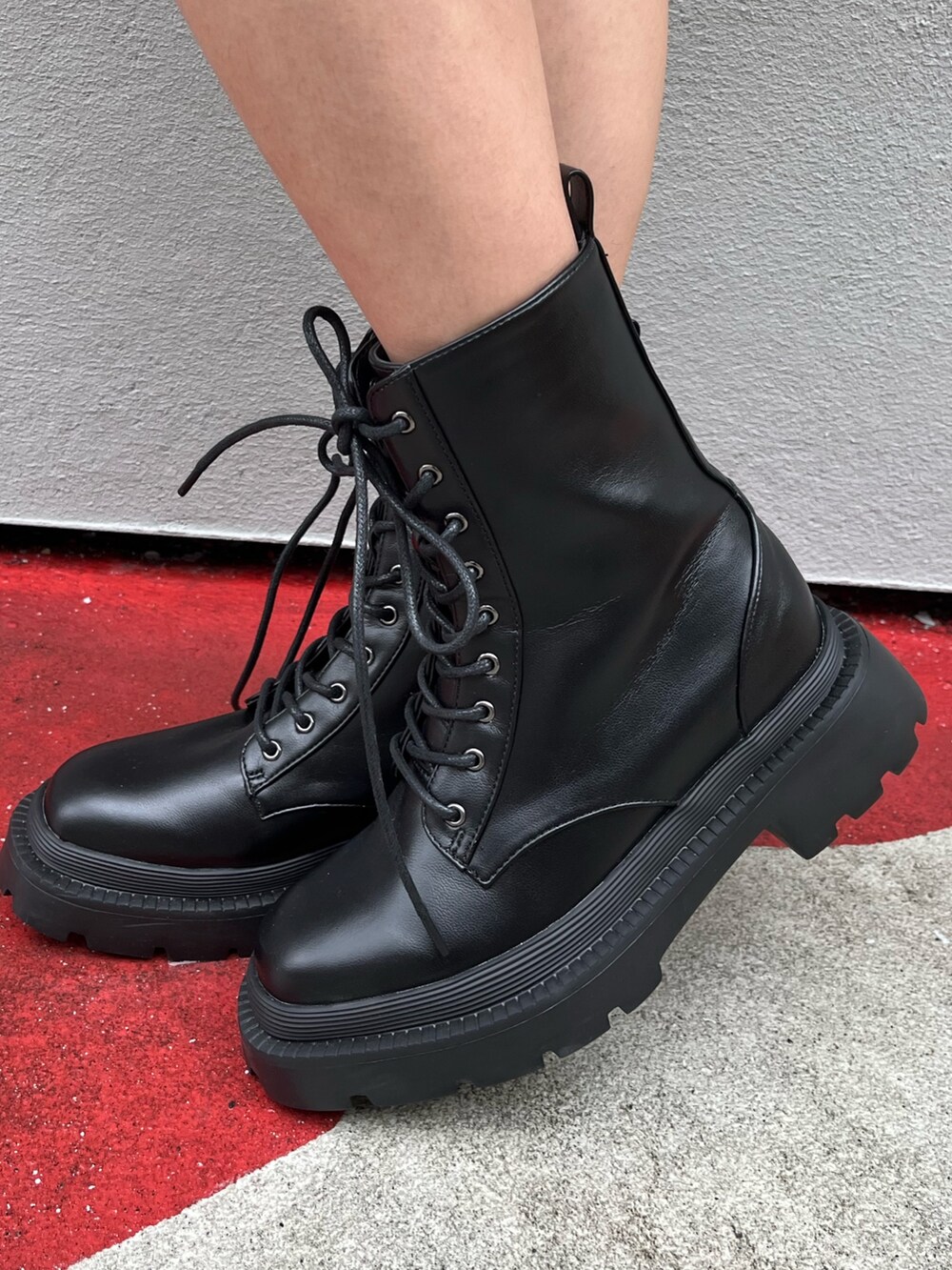 ブラウン系のハンドバッグ、ブラック系のブーツ、ブラック系のTシャツ/カットソーを着用したレディースの春コーディネートの7枚目の写真