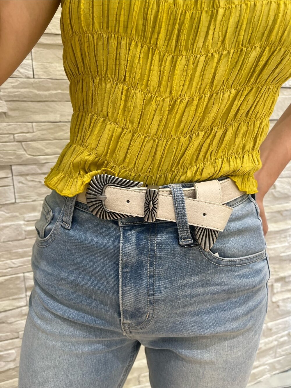 イエロー系のシャツ/ブラウス、ブラック系のサンダル、ブルー系のデニムパンツを着用したレディースの夏コーディネートの3枚目の写真