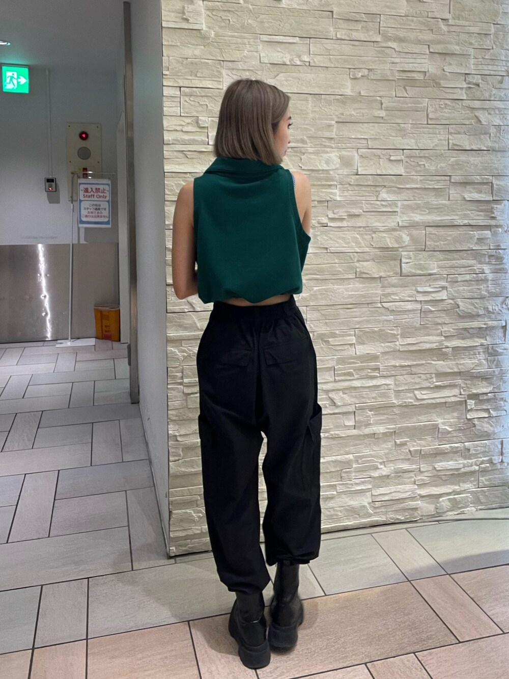 ブラック系のタンクトップ、パープル系のカーゴパンツ、ブラック系のブーツを着用したレディースの春コーディネートの4枚目の写真