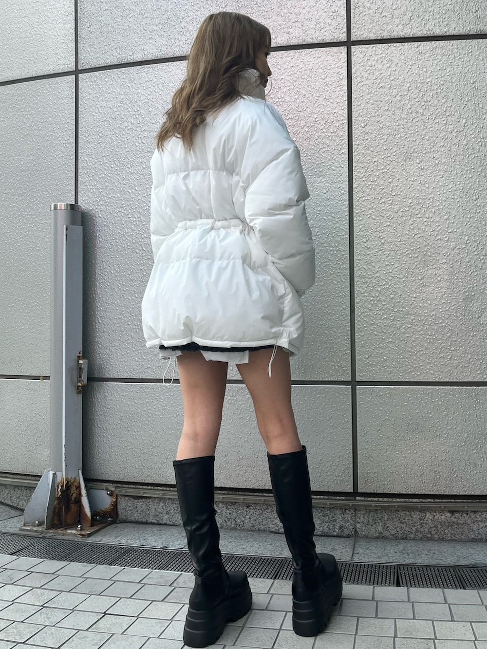 ブラック系のデニムスカート、ブラック系のTシャツ/カットソー、ブラック系のブーツを着用したレディースの冬コーディネートの4枚目の写真