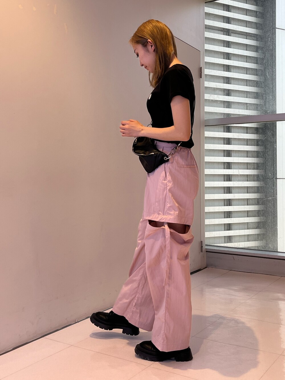 ピンク系のカーゴパンツ、シルバー系のボディバッグ/ウエストポーチ、ブラック系のTシャツ/カットソーを着用したレディースの春コーディネートの4枚目の写真