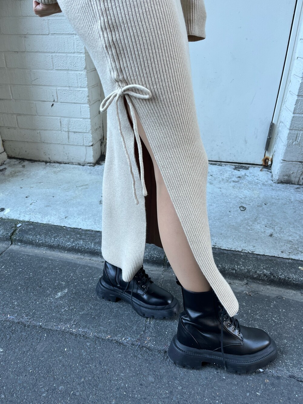 ホワイト系のワンピース、グリーン系のその他アウター、ブラック系のブーツを着用したレディースの冬コーディネートの6枚目の写真