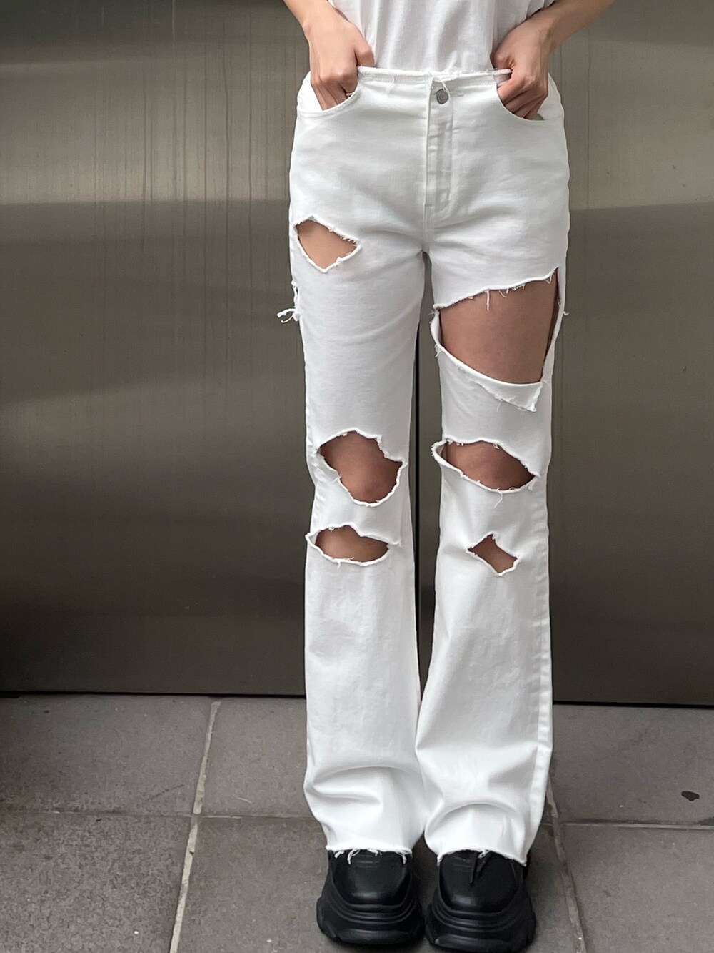 ホワイト系のデニムパンツ、ホワイト系のTシャツ/カットソー、ブラック系のスニーカーを着用したレディースの春コーディネートの7枚目の写真