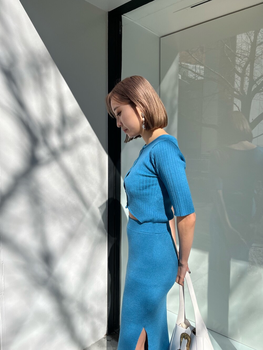 ブルー系のワンピース、ブラック系のハンドバッグを着用したレディースの春コーディネートの6枚目の写真