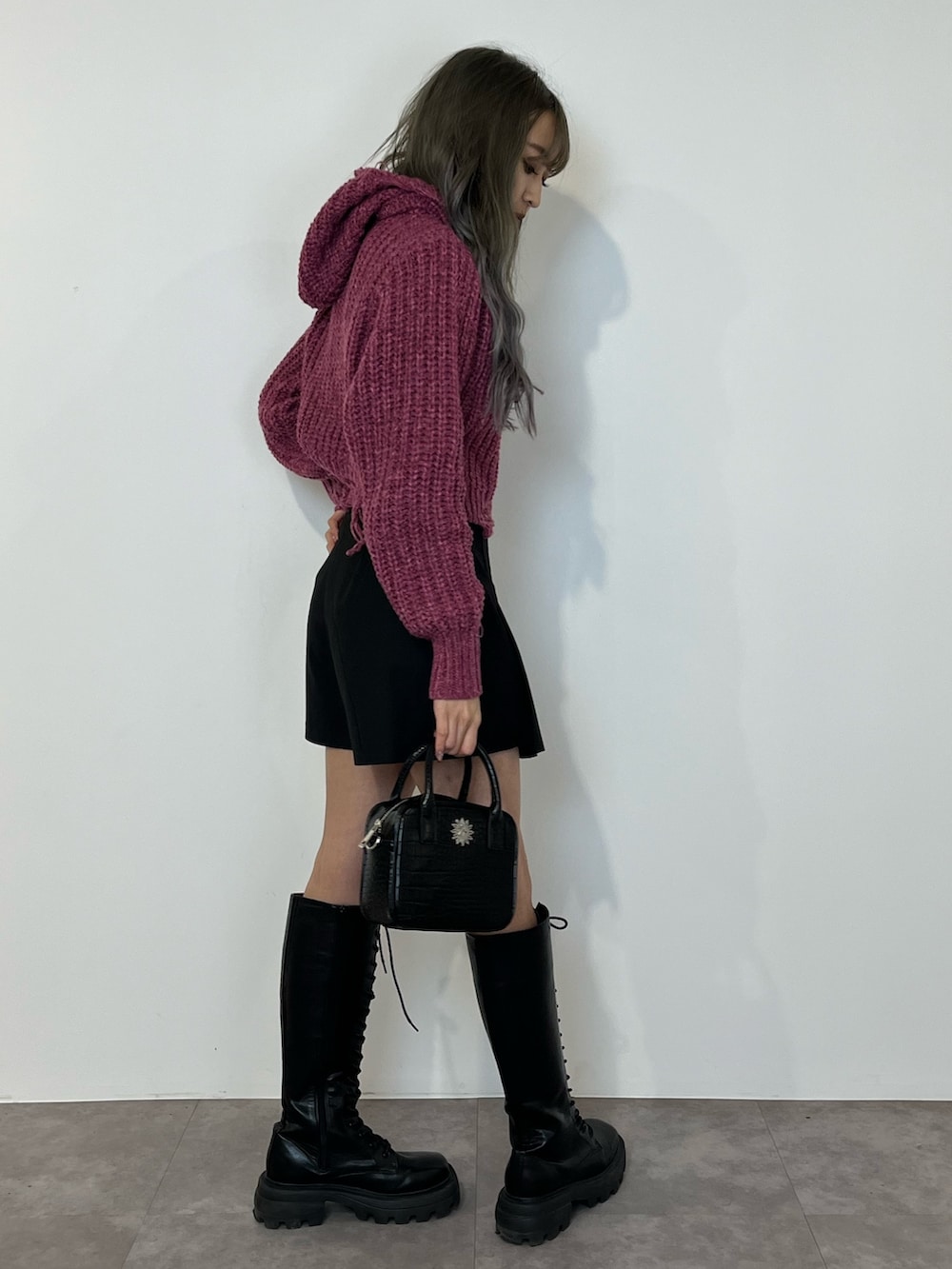 パープル系のニット/セーター、ブラック系のその他パンツ、ブラック系のブーツを着用したレディースの冬コーディネートの4枚目の写真