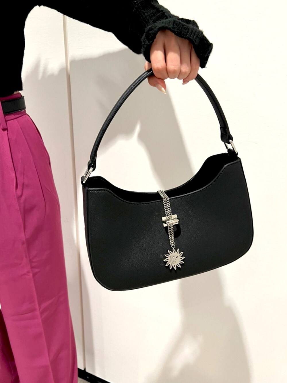 ブラック系のニット/セーター、パープル系のスラックス、ブラック系のハンドバッグを着用したレディースの秋コーディネートの4枚目の写真