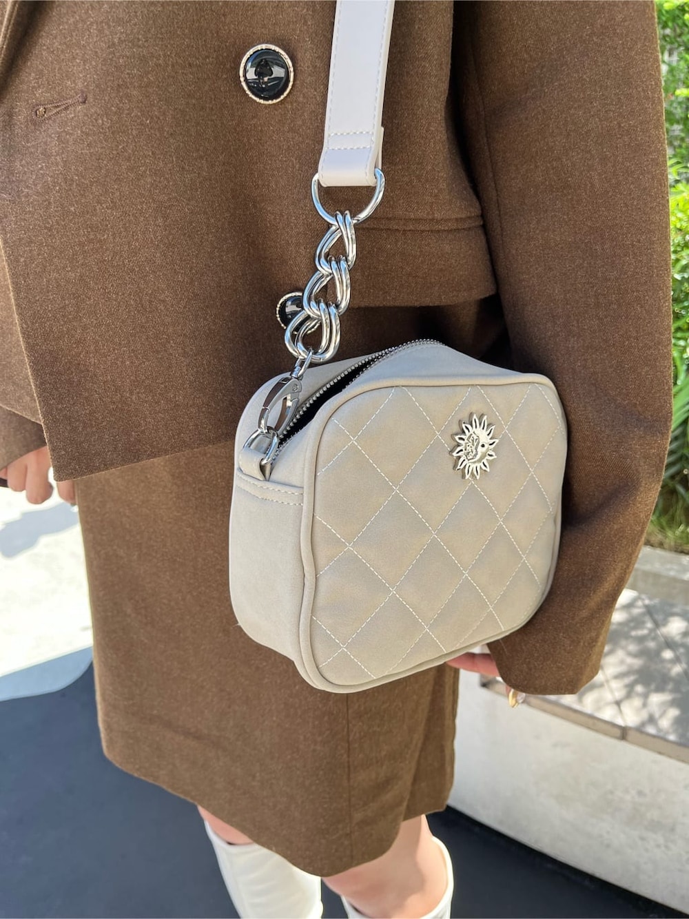 ブラウン系のスカート、ブラック系のニット/セーター、ブラック系のブーツを着用したレディースの秋コーディネートの5枚目の写真