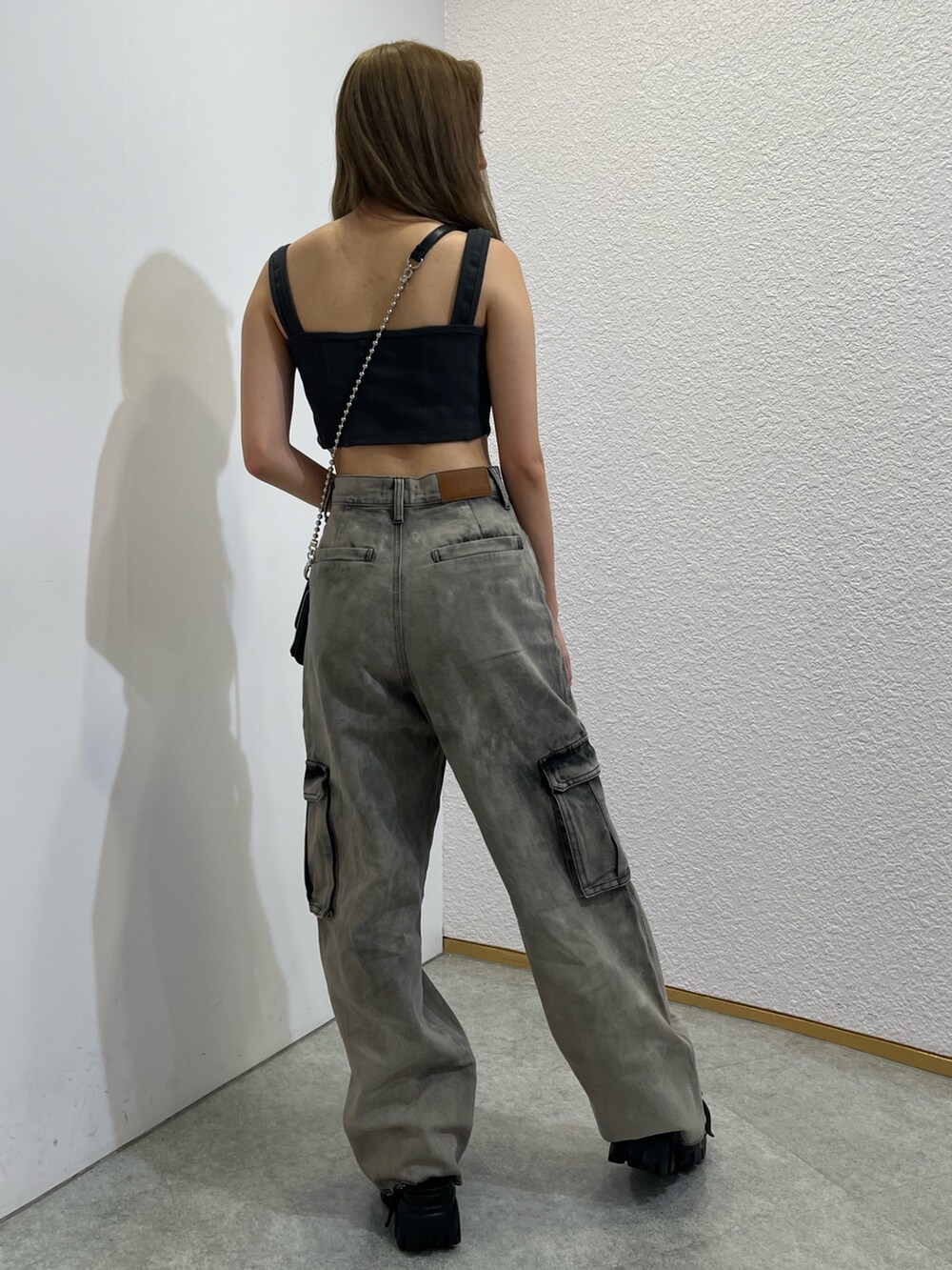 シルバー系のショルダーバッグ、ブラック系のキャミソール、ブラック系のデニムパンツを着用したレディースの夏コーディネートの3枚目の写真