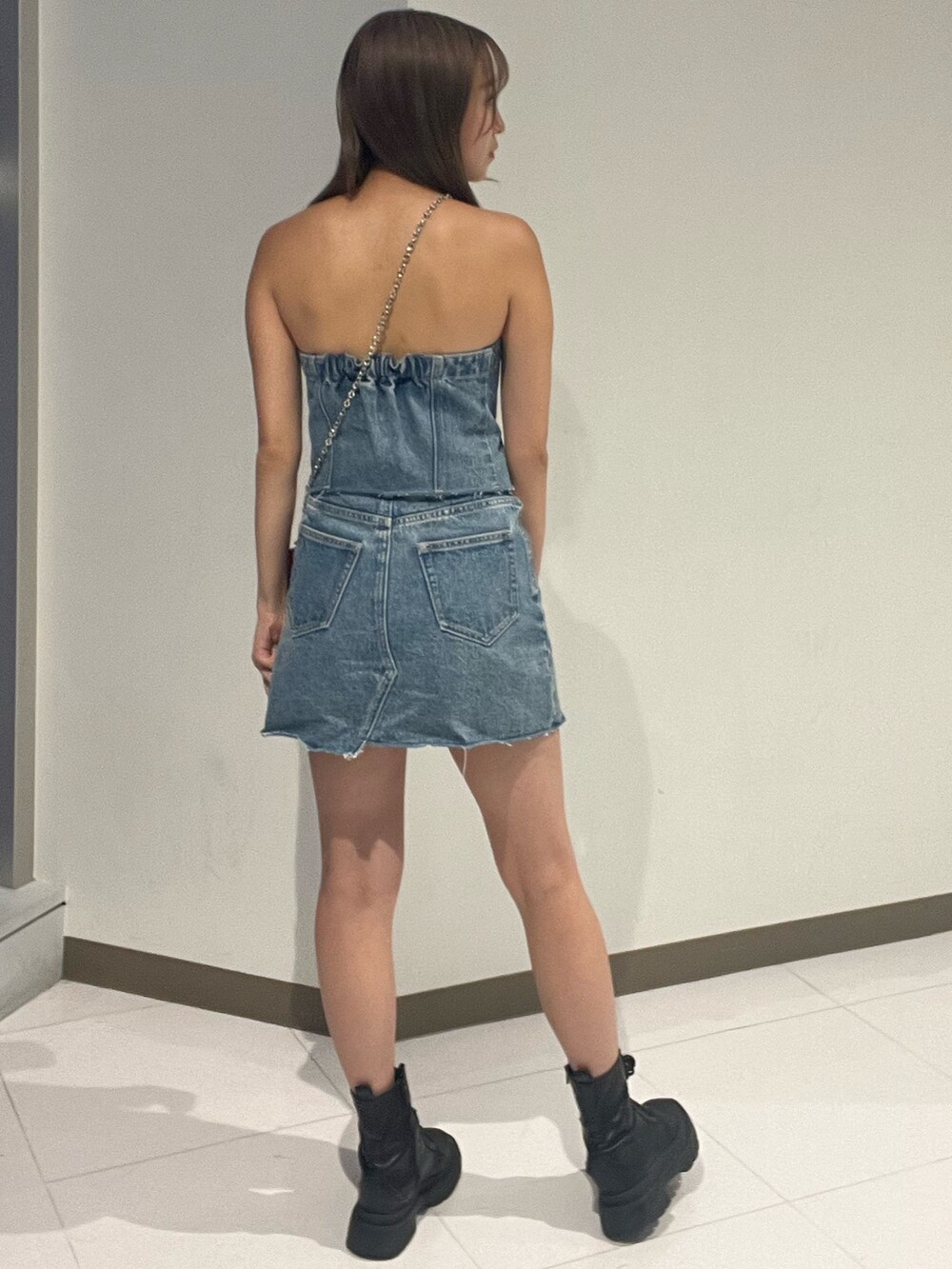 ブルー系のキャミソール、ブラック系のデニムスカート、シルバー系のブーツを着用したレディースの夏コーディネートの6枚目の写真